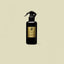 Black orchid room spray in a black bottle with a gold label on a beige background.