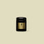 ZENZAR Oud Wood luxury candle in a matte black jar with gold detailing on a beige background.